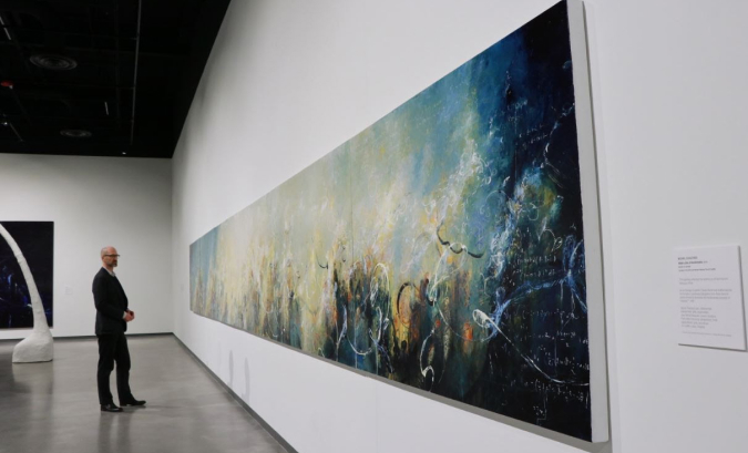 Person looking at a very large painting on the wall